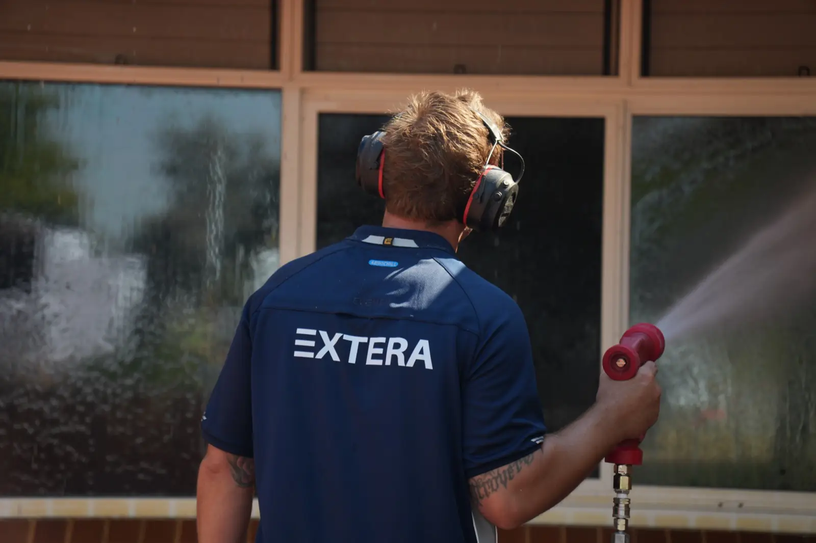 Extera cleaning large windows in Perth, water sheeting down the glass
